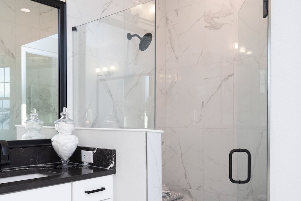 Dark countertop sink and shower next to it