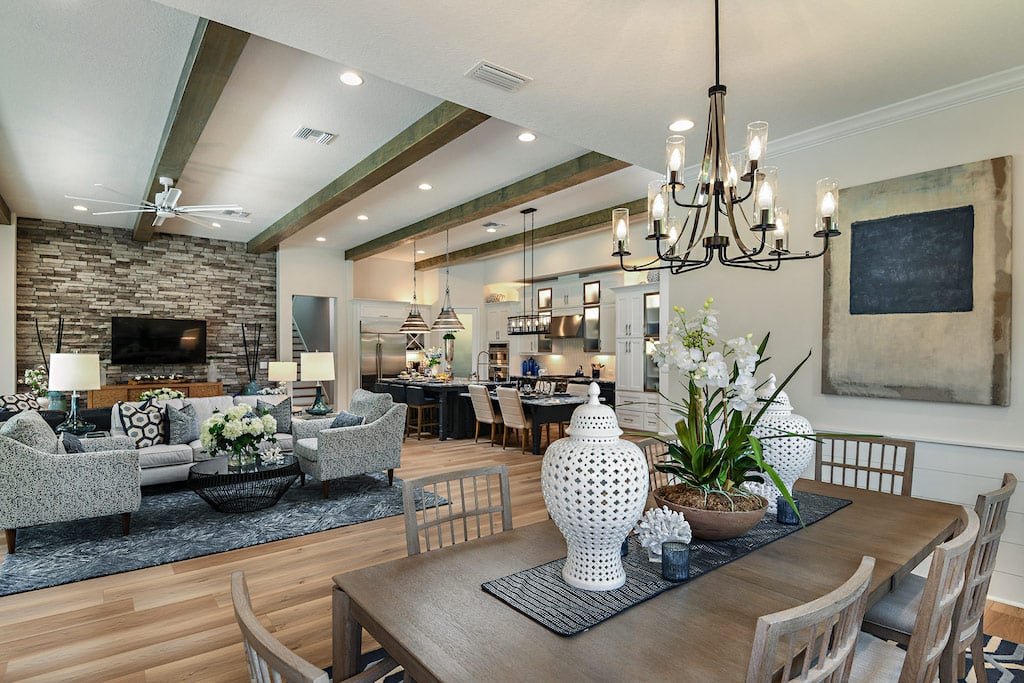 Interior image with exposed ceilings, dining table, sofa area, and kitchen